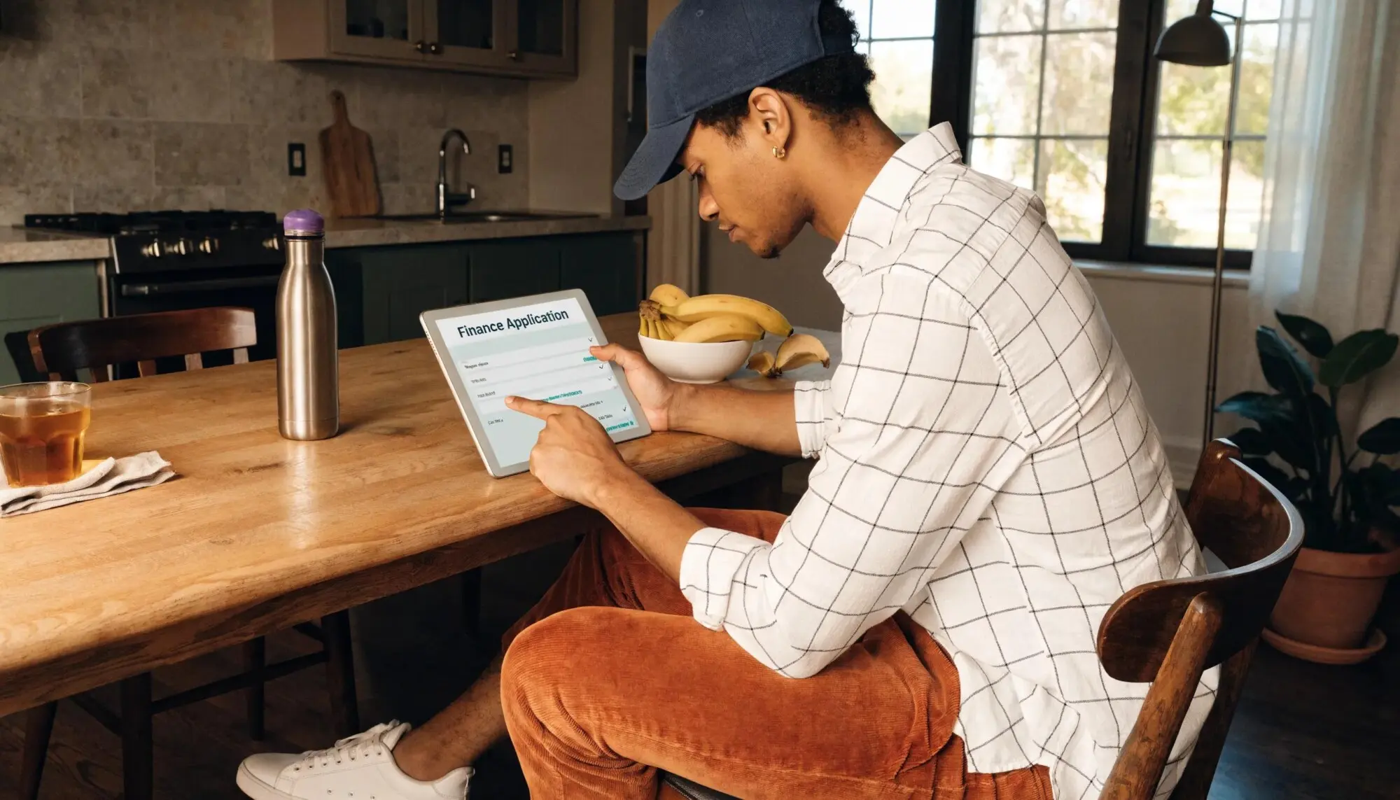 Homeowner reviewing roof replacement finance application on tablet.